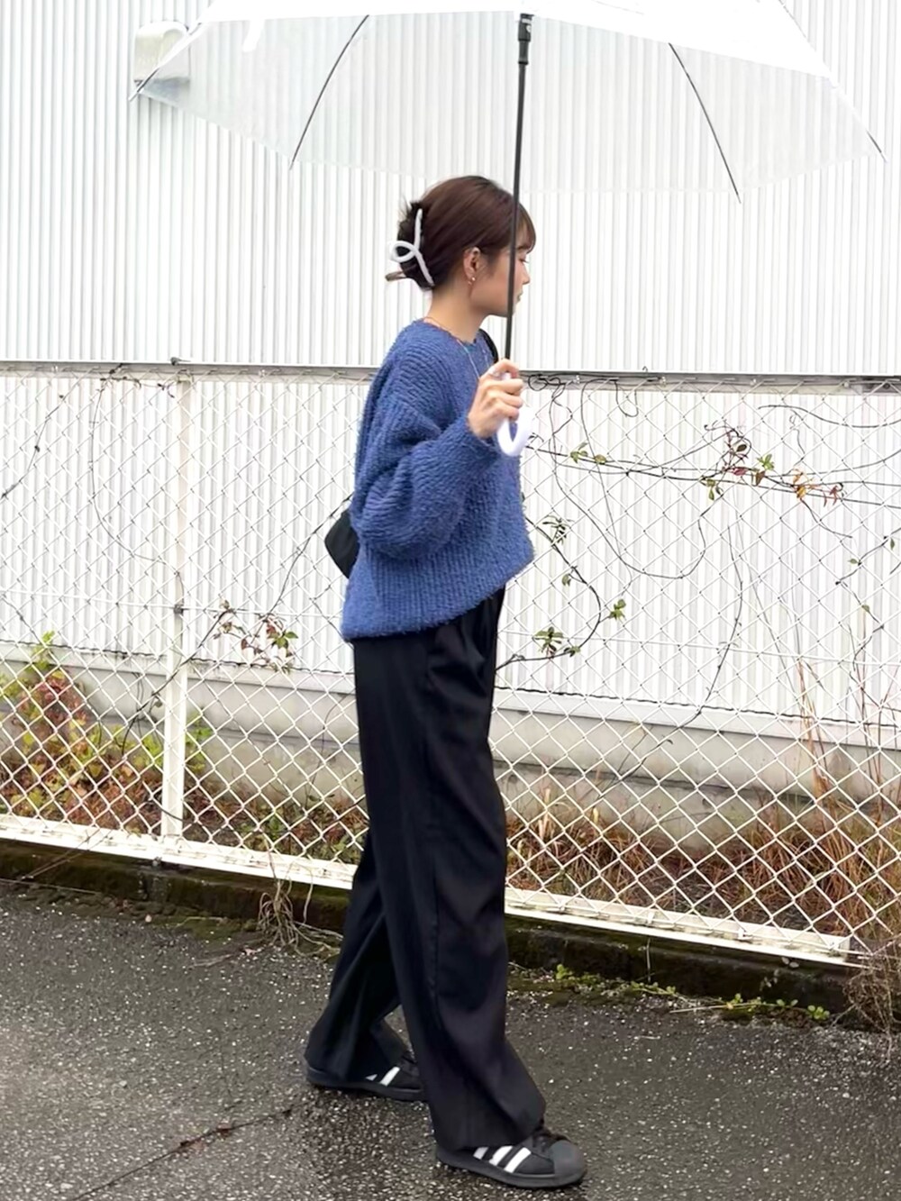 ブルー系のニット/セーター、ブラック系のショルダーバッグ、ブラック系のスラックスを着用したレディースの冬コーディネートの3枚目の写真