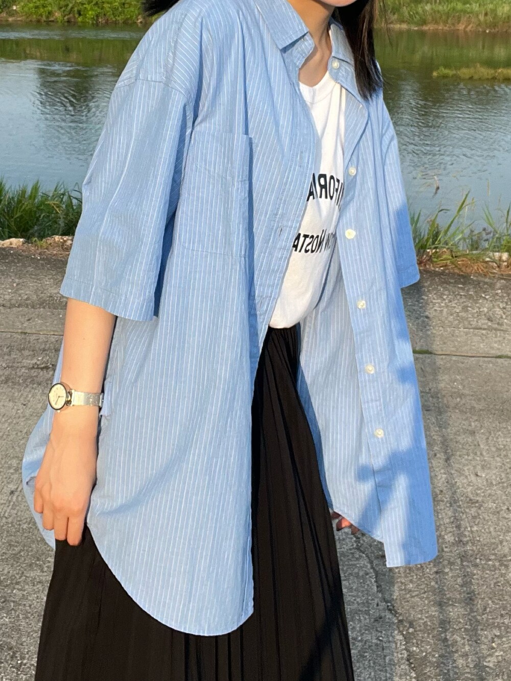 ブルー系のシャツ/ブラウス、ホワイト系のTシャツ/カットソー、ブラック系のスカートを着用したレディースの夏コーディネートの2枚目の写真