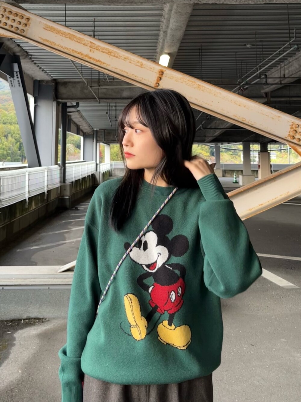 ブラック系のその他アウター、グリーン系のニット/セーター、ブラウン系のスラックスを着用したレディースの冬コーディネートの4枚目の写真