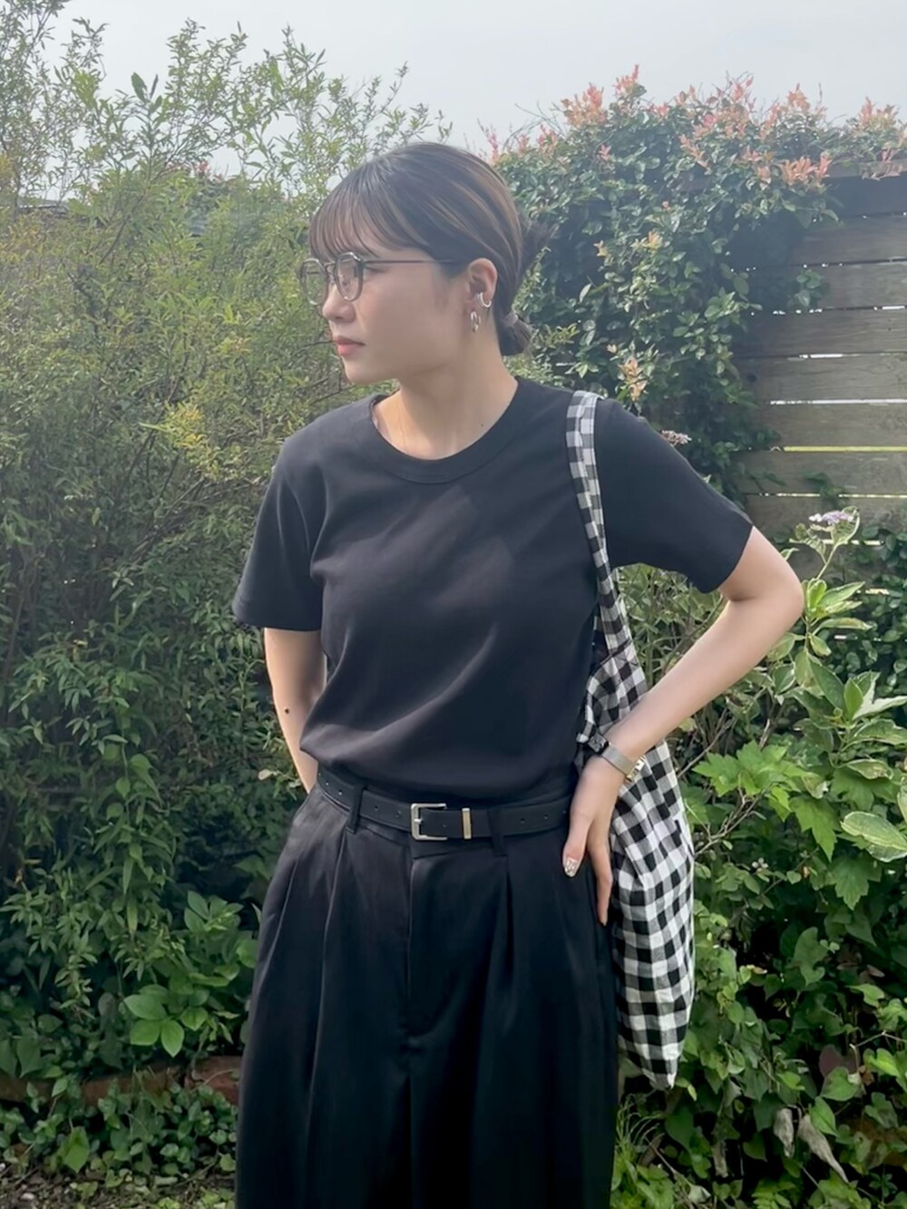 ブラック系のTシャツ/カットソー、ブラック系のスラックス、ブラック系のトートバッグを着用したレディースの夏コーディネートの2枚目の写真