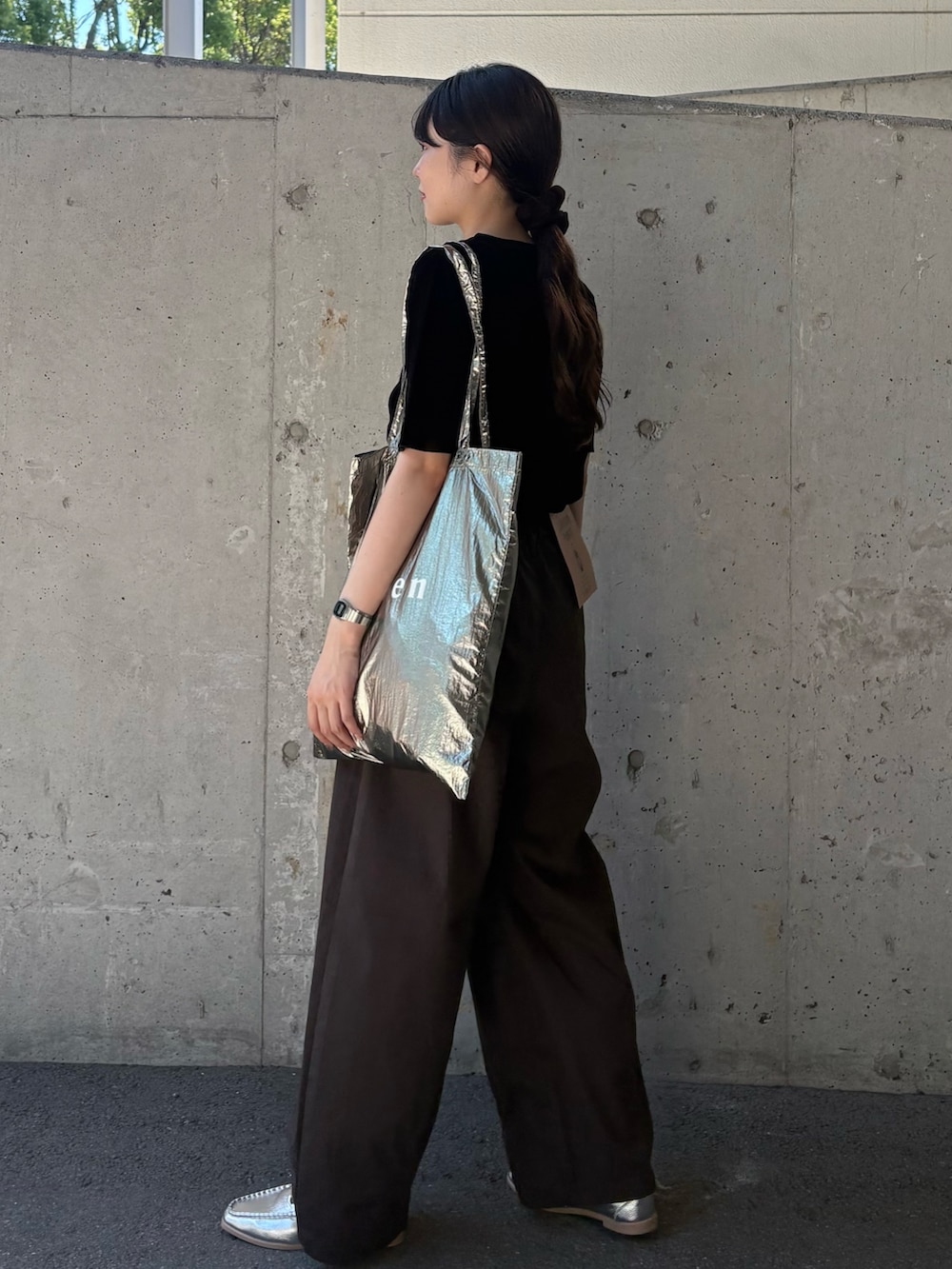 ブラック系のTシャツ/カットソー、グレー系のチノパンツ、シルバー系のトートバッグを着用したレディースの秋コーディネートの4枚目の写真