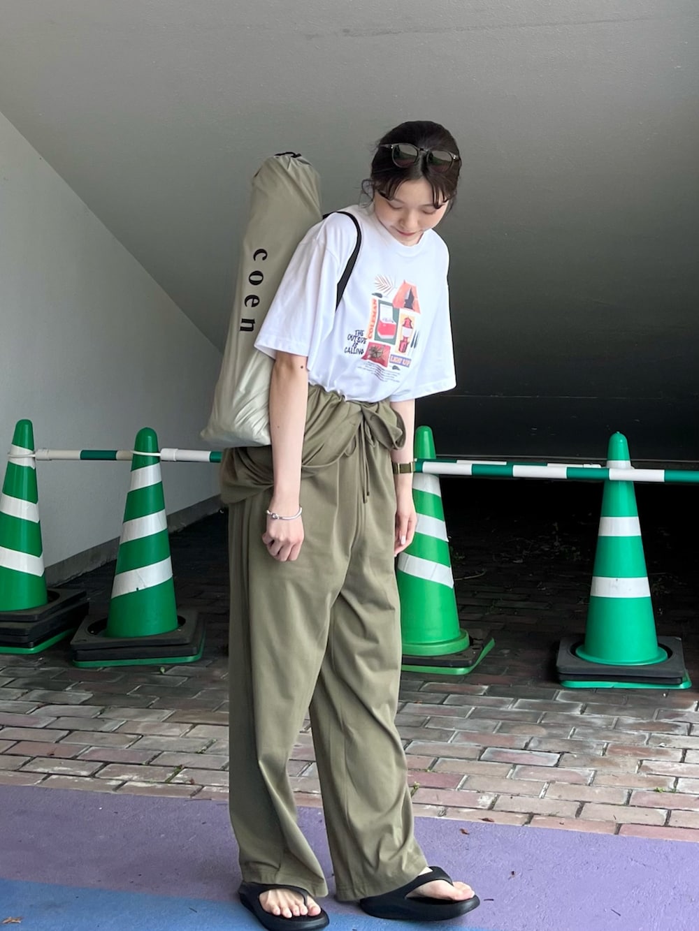 ブラック系のサンダル、グリーン系のサロペット/オーバーオール、その他のTシャツ/カットソーを着用したレディースの春コーディネートの2枚目の写真