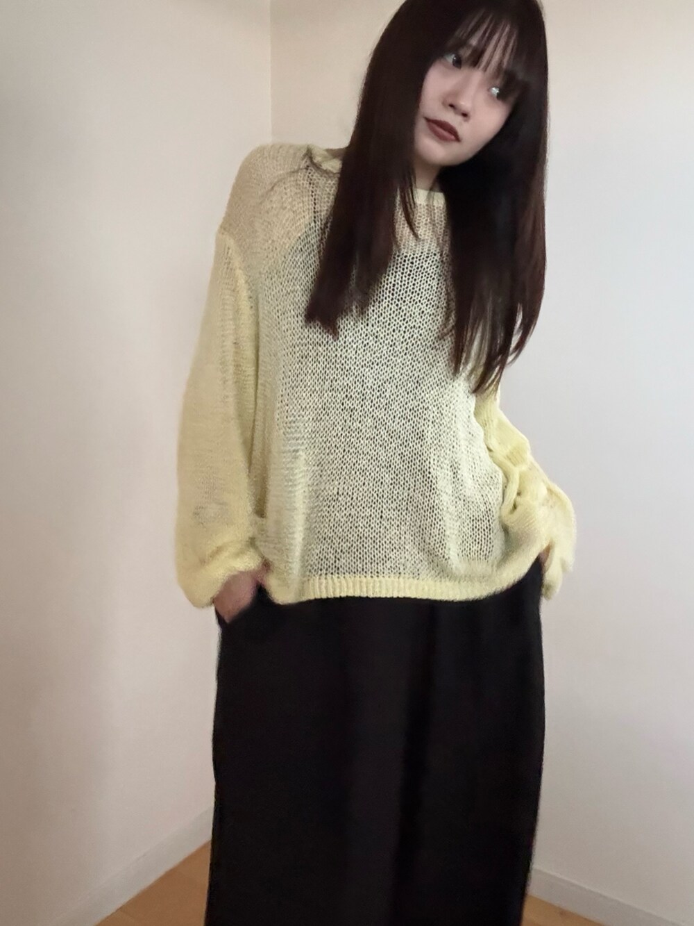 イエロー系のニット/セーター、ブラック系のスラックスを着用したレディースの春コーディネートの4枚目の写真