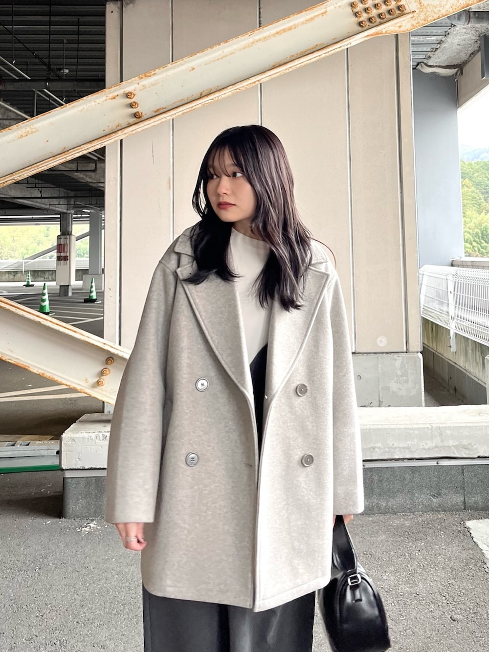 ホワイト系のニット/セーター、グレー系のジャンパースカート、グレー系のその他アウターを着用したレディースの冬コーディネートの4枚目の写真