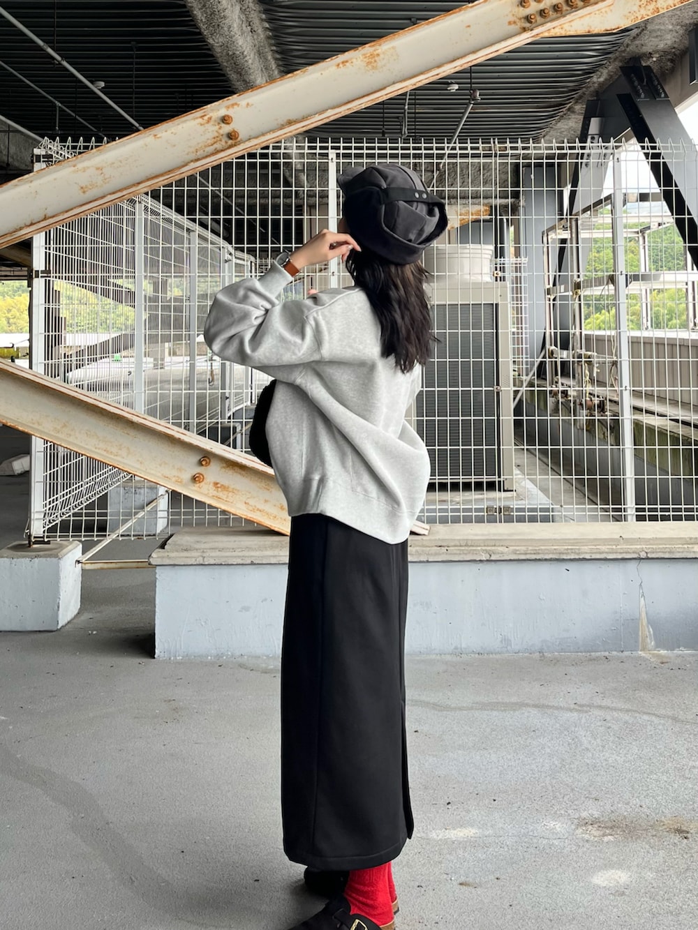 グレー系のスウェット、ブラック系のスカート、ブラック系のサンダルを着用したレディースの冬コーディネートの3枚目の写真