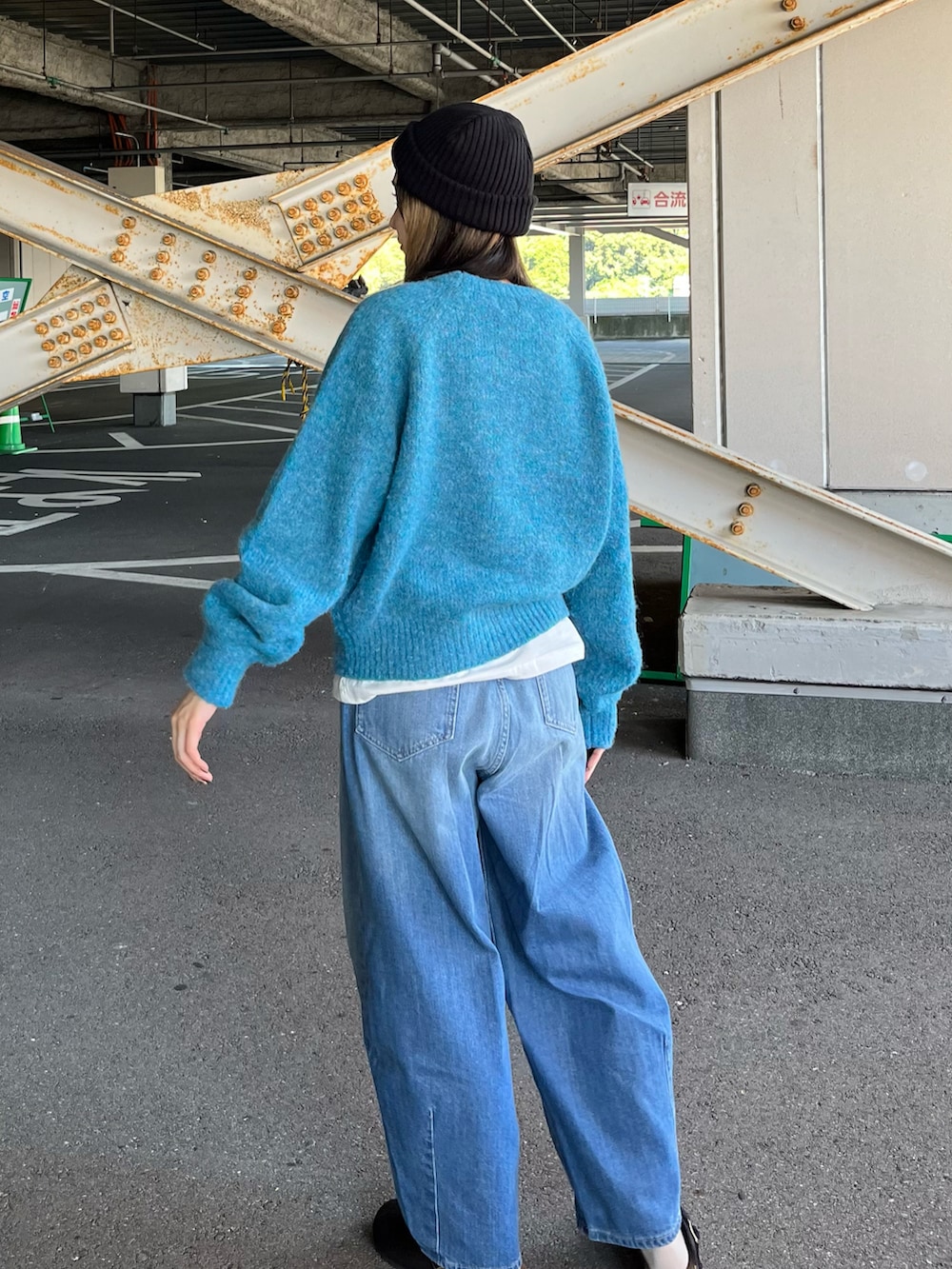 ブルー系のニット/セーター、ホワイト系のTシャツ/カットソー、ブルー系のデニムパンツを着用したレディースの秋コーディネートの5枚目の写真