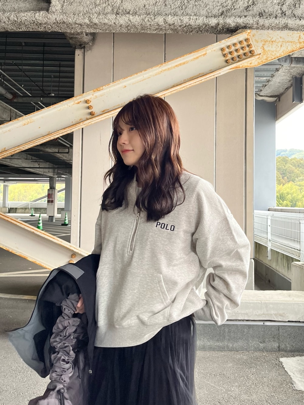 ブラック系のナイロンジャケット、グレー系のスウェット、ブラック系のスカートを着用したレディースの冬コーディネートの4枚目の写真