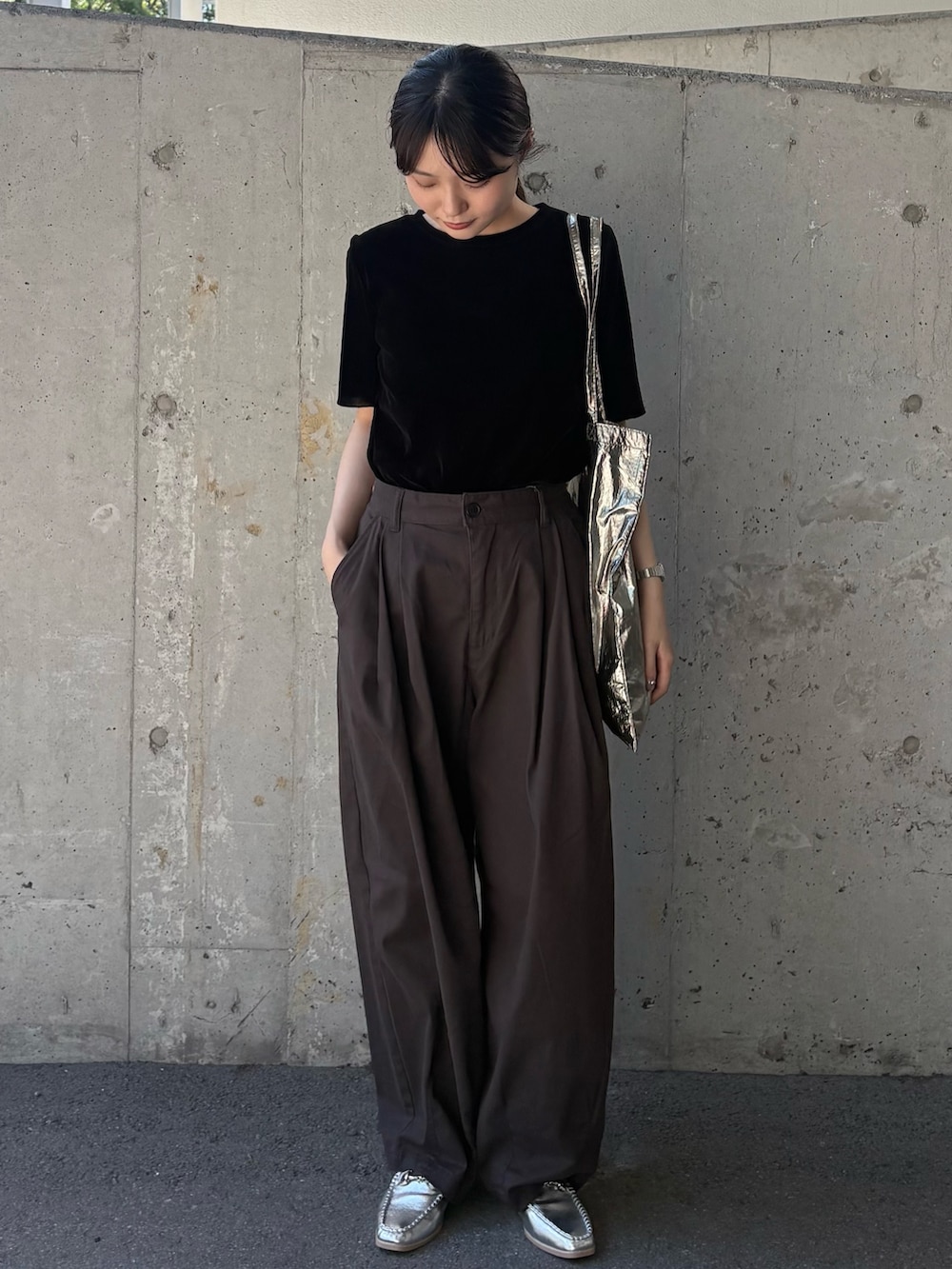 ブラック系のTシャツ/カットソー、グレー系のチノパンツ、シルバー系のトートバッグを着用したレディースの秋コーディネートの2枚目の写真