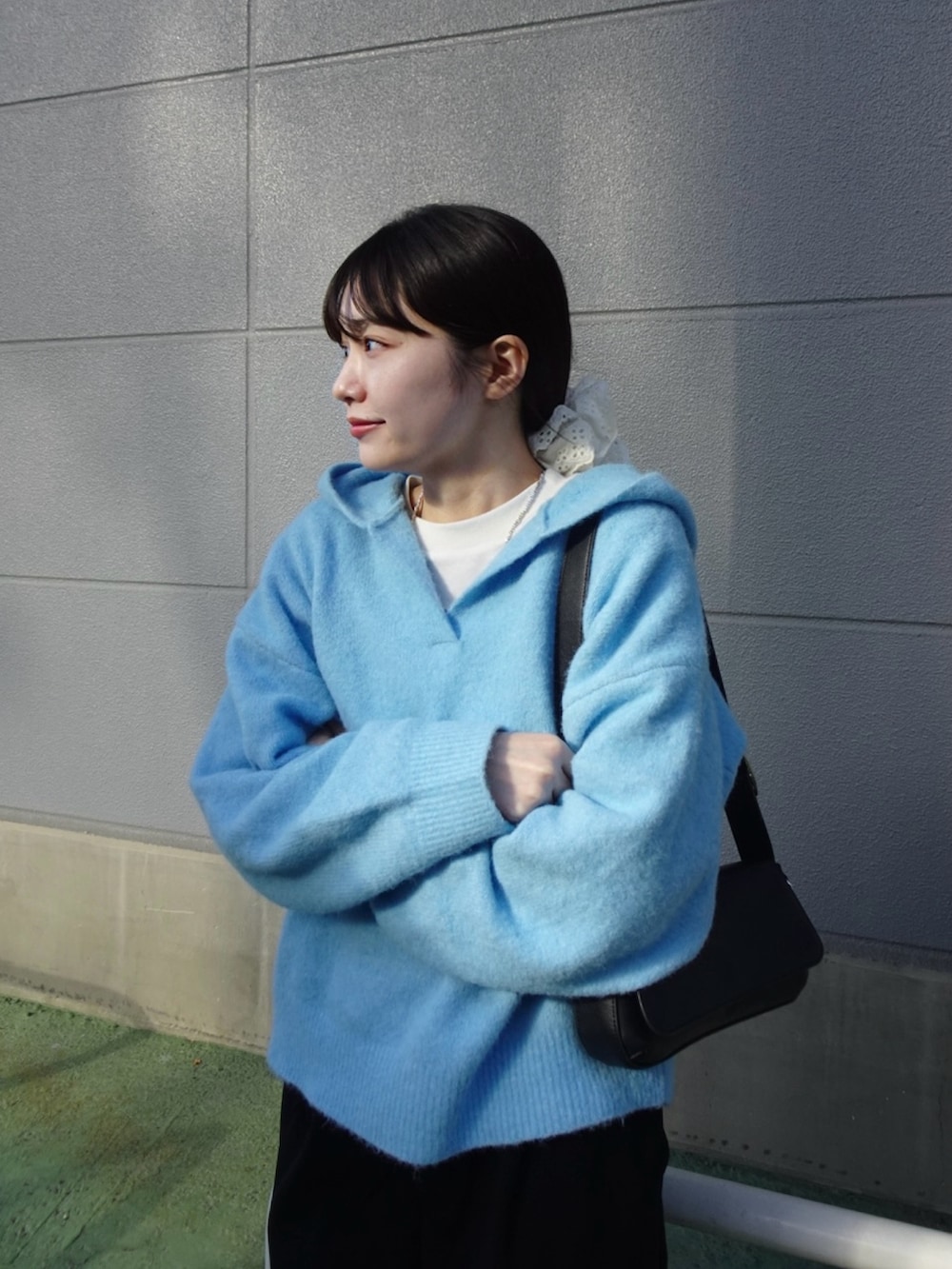 ブラック系のスラックス、ブルー系のニット/セーター、ホワイト系のスニーカーを着用したレディースの冬コーディネートの5枚目の写真