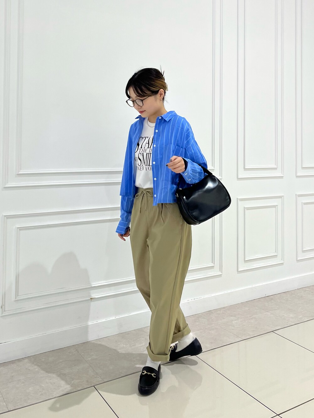 ベージュ系のその他パンツ、ブラック系のローファー、ブラック系のショルダーバッグを着用したレディースの夏コーディネートの2枚目の写真