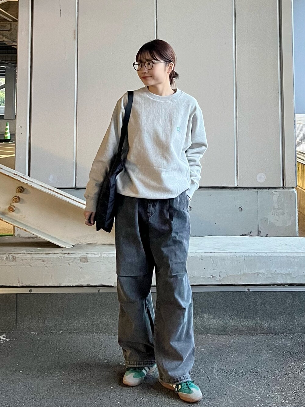 グレー系のデニムパンツ、ブラック系のトートバッグ、グリーン系のスニーカーを着用したレディースの冬コーディネートの4枚目の写真