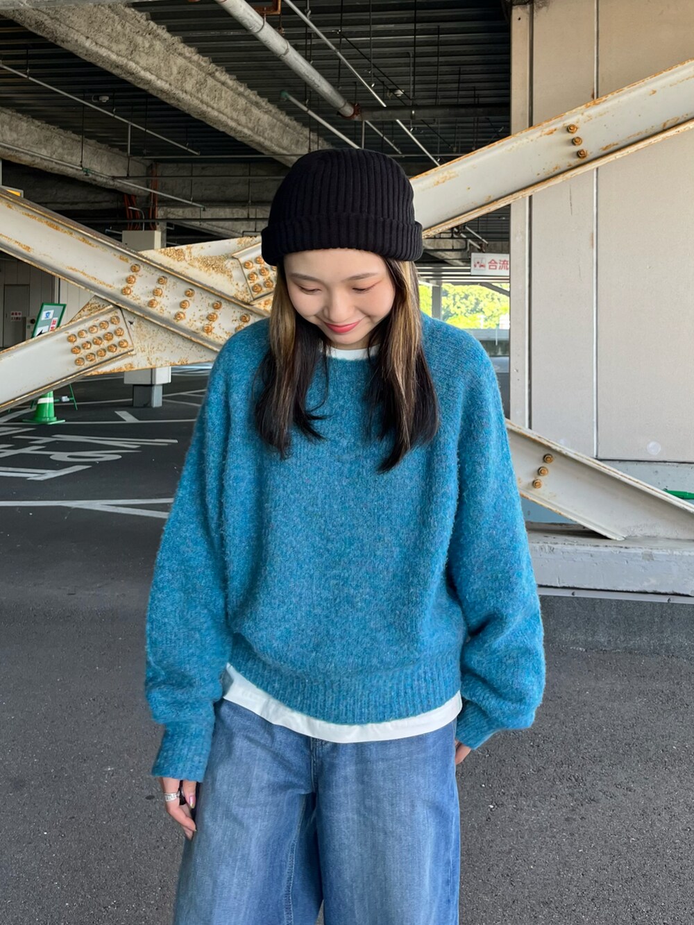 ブルー系のニット/セーター、ホワイト系のTシャツ/カットソー、ブルー系のデニムパンツを着用したレディースの秋コーディネートの4枚目の写真