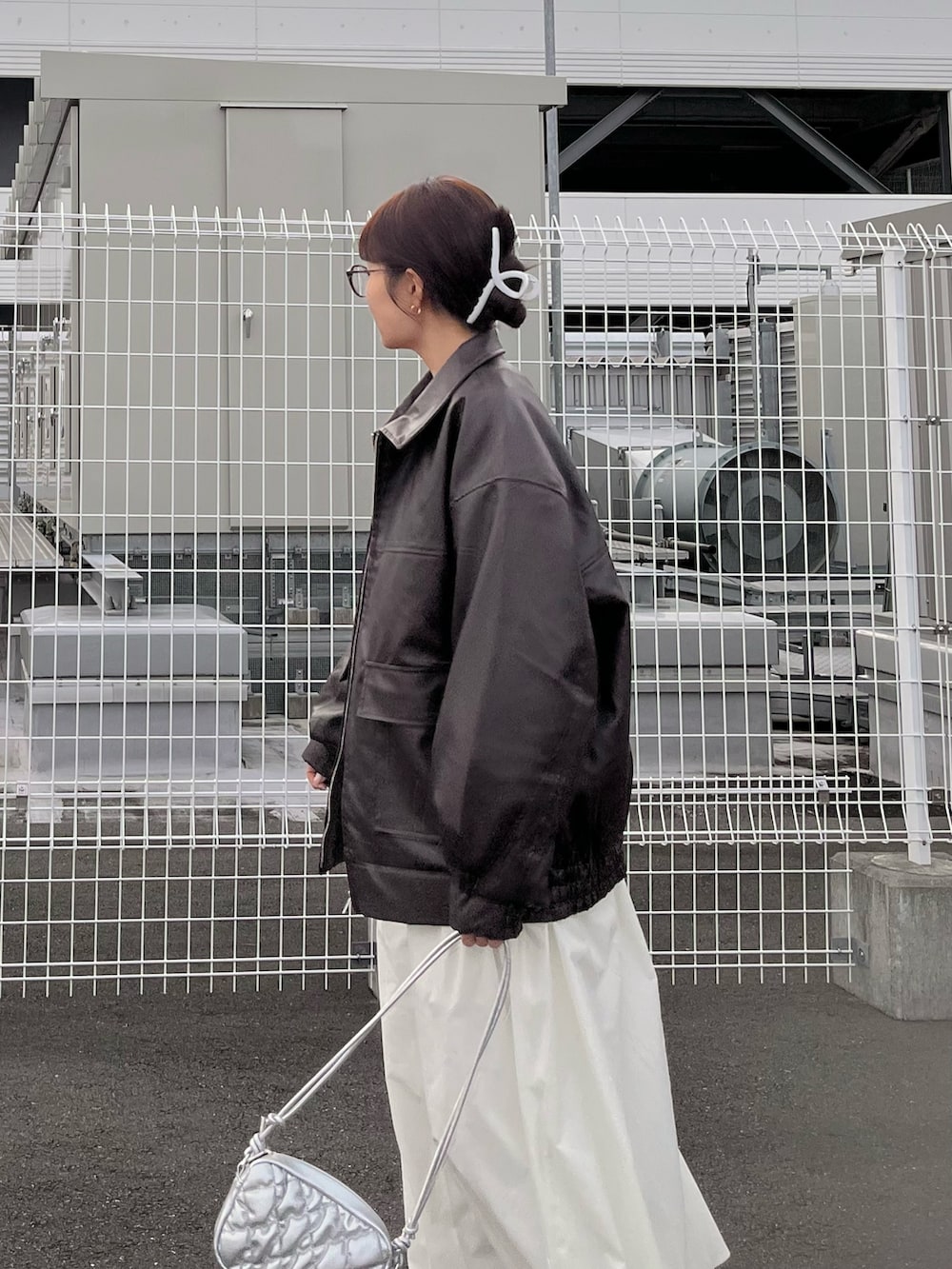 ピンク系のニット/セーター、ブラウン系のブルゾン、ホワイト系のスカートを着用したレディースの冬コーディネートの2枚目の写真