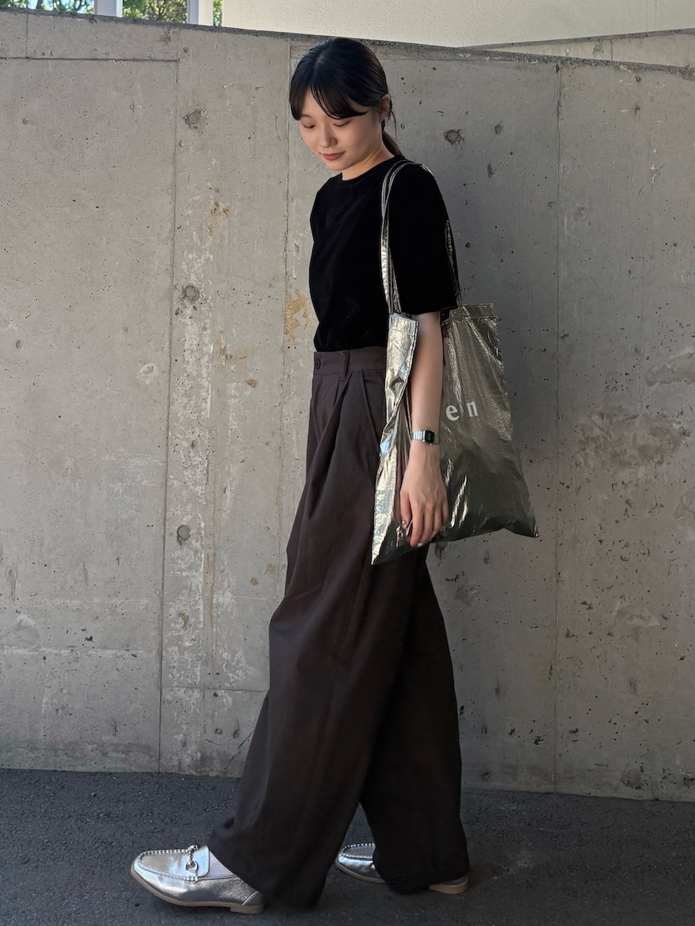 ブラック系のTシャツ/カットソー、グレー系のチノパンツ、シルバー系のトートバッグを着用したレディースの秋コーディネートの3枚目の写真