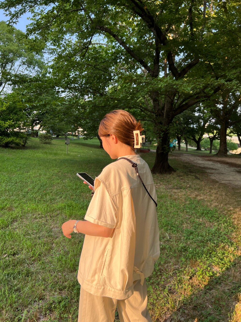 ホワイト系のベスト、ブラック系のサンダル、ベージュ系のTシャツ/カットソーを着用したレディースの夏コーディネートの2枚目の写真