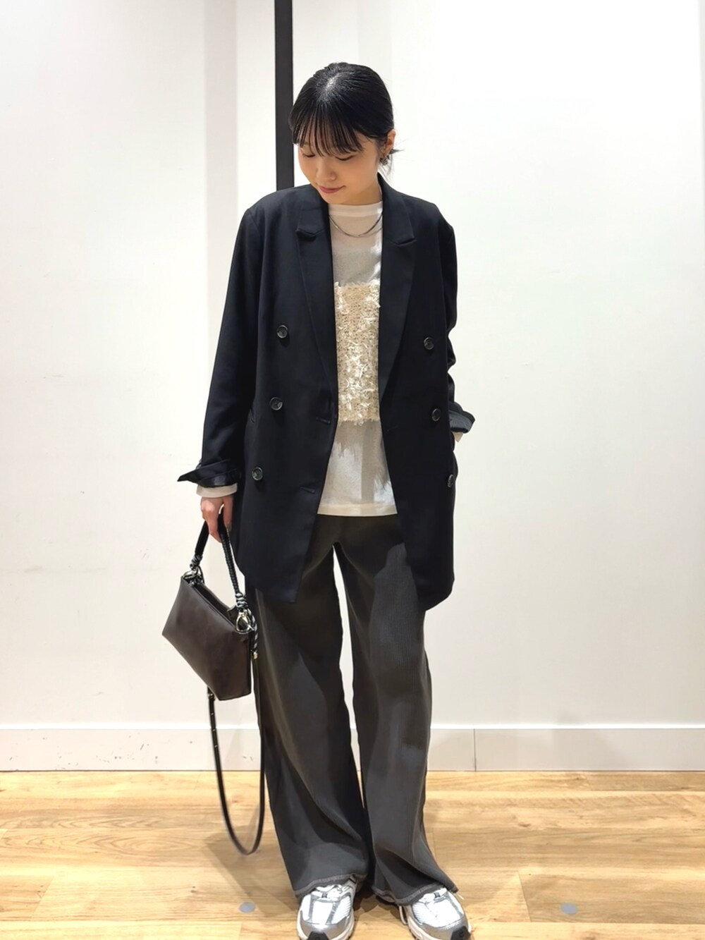 ブラック系のテーラードジャケット、ホワイト系のTシャツ/カットソー、ホワイト系のキャミソールを着用したレディースの春コーディネートの2枚目の写真