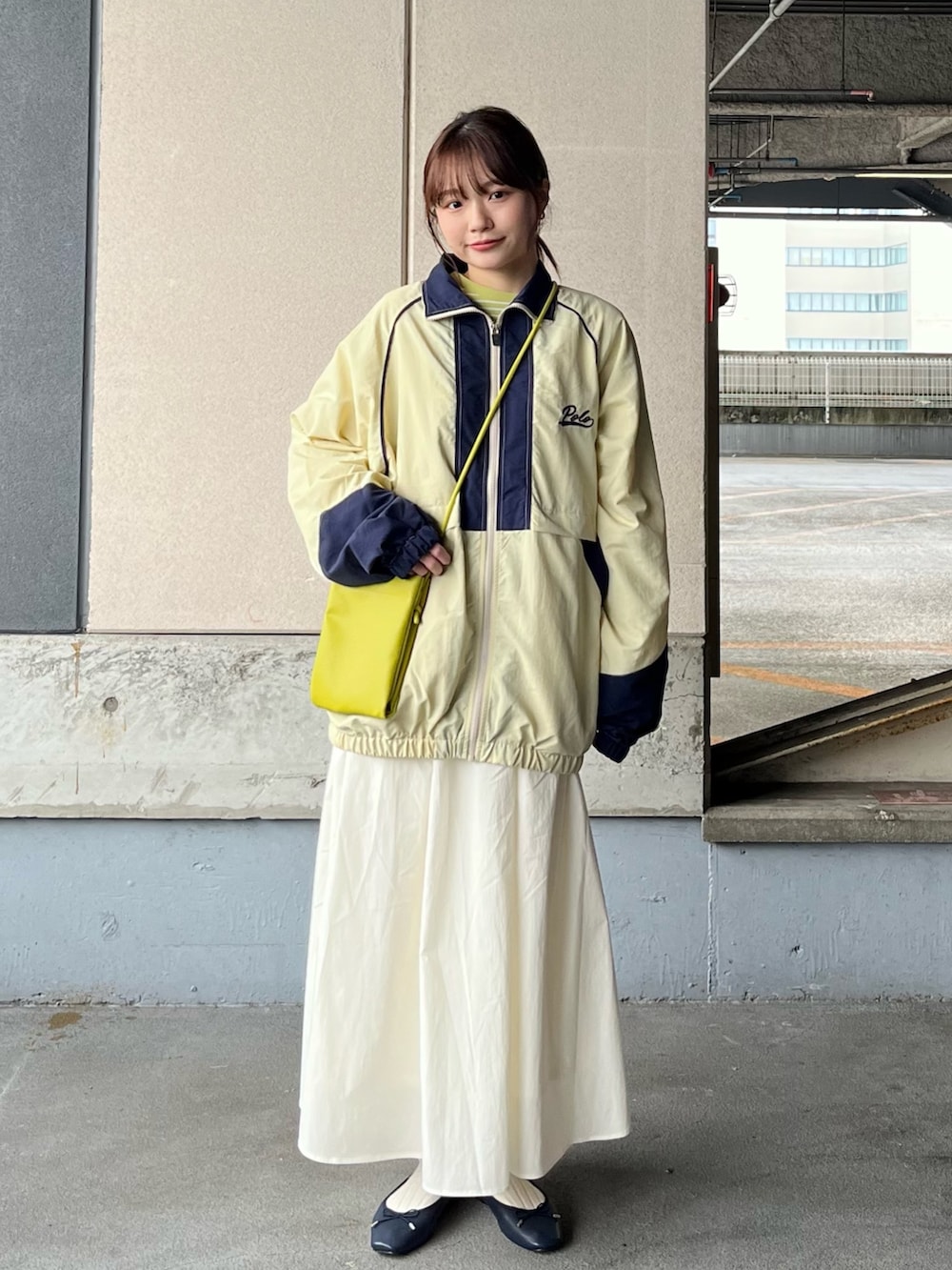 ベージュ系のナイロンジャケット、グリーン系のTシャツ/カットソー、グリーン系のショルダーバッグを着用したレディースの冬コーディネートの2枚目の写真