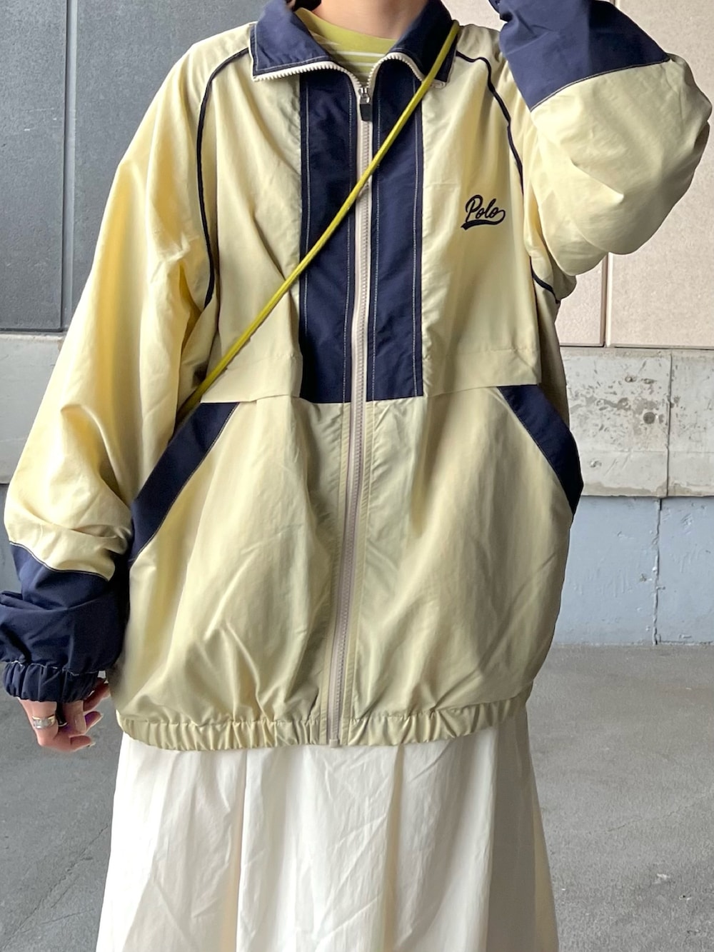 ベージュ系のナイロンジャケット、グリーン系のTシャツ/カットソー、グリーン系のショルダーバッグを着用したレディースの冬コーディネートの3枚目の写真