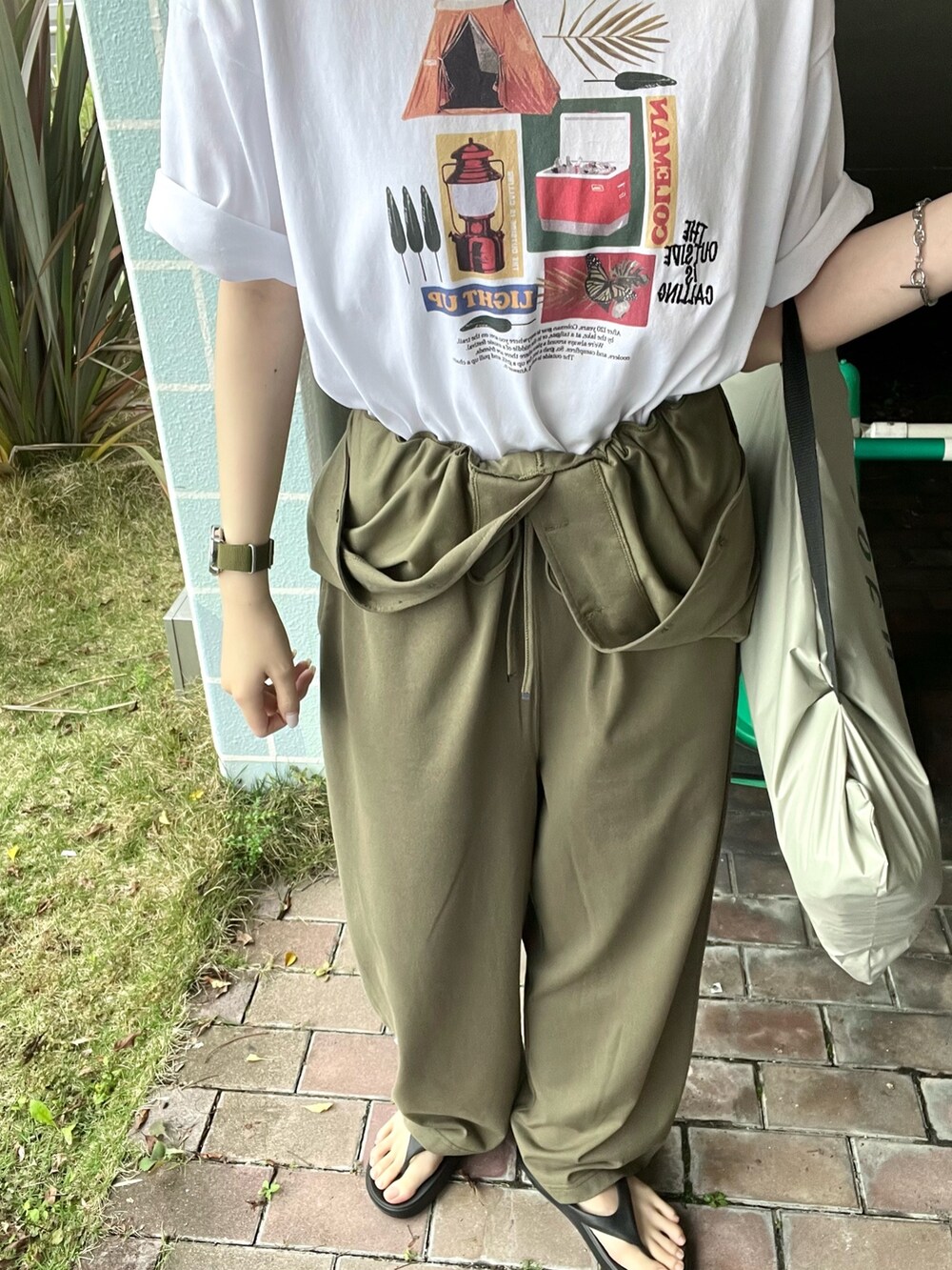 ブラック系のサンダル、グリーン系のサロペット/オーバーオール、その他のTシャツ/カットソーを着用したレディースの春コーディネートの4枚目の写真