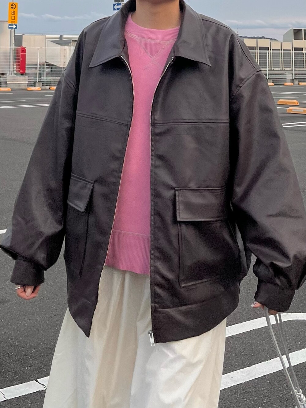 ピンク系のニット/セーター、ブラウン系のブルゾン、ホワイト系のスカートを着用したレディースの冬コーディネートの4枚目の写真