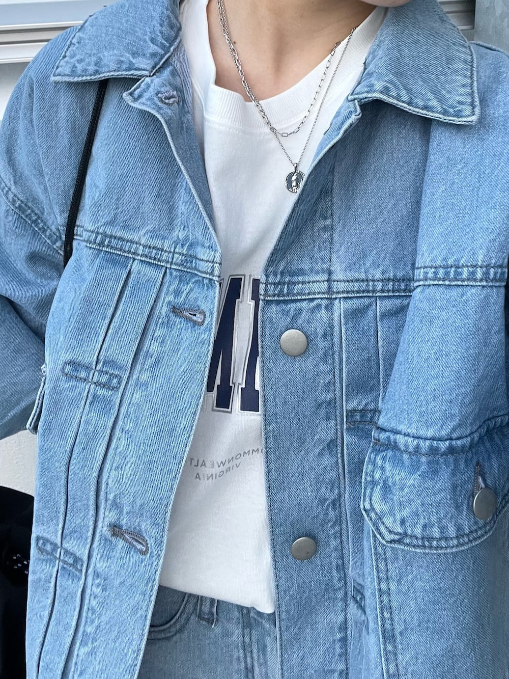 ブルー系のデニムジャケット、ブルー系のデニムパンツ、ホワイト系のTシャツ/カットソーを着用したレディースの冬コーディネートの5枚目の写真