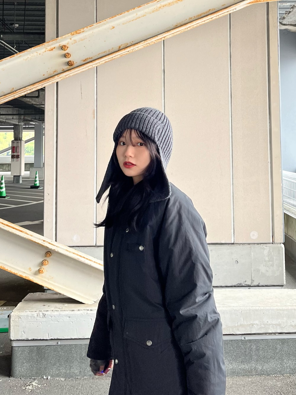 ブラック系のブルゾン、ブラック系のスラックス、ブラック系のショルダーバッグを着用したレディースの冬コーディネートの4枚目の写真