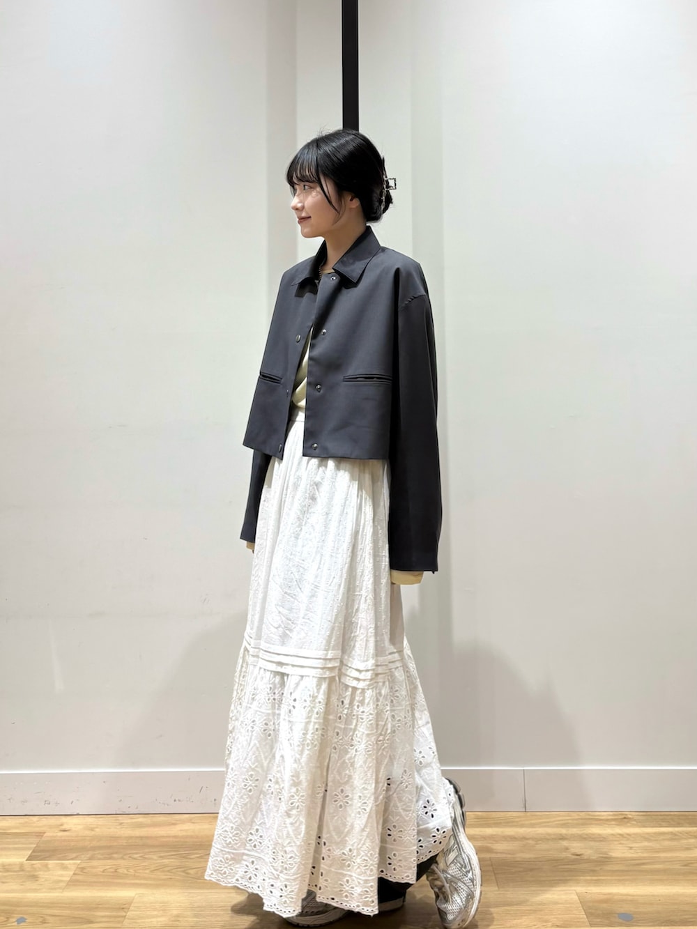 グレー系のテーラードジャケット、ベージュ系のTシャツ/カットソー、ホワイト系のスカートを着用したレディースの春コーディネートの2枚目の写真