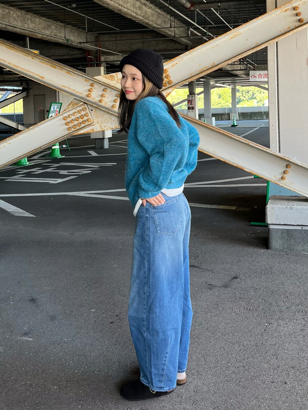 ブルー系のニット/セーター、ホワイト系のTシャツ/カットソー、ブルー系のデニムパンツを着用したレディースの秋コーディネートの3枚目の写真