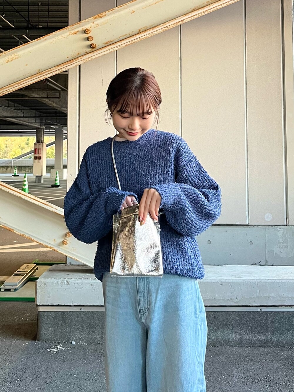 シルバー系のショルダーバッグ、ブルー系のデニムパンツ、ブルー系のニット/セーターを着用したレディースの冬コーディネートの4枚目の写真