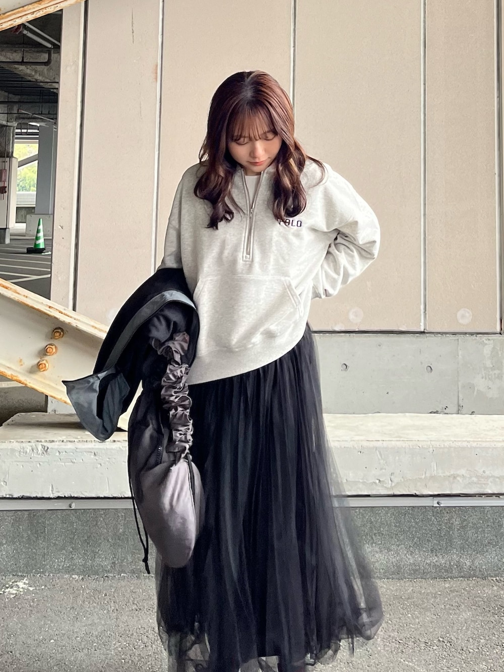 ブラック系のナイロンジャケット、グレー系のスウェット、ブラック系のスカートを着用したレディースの冬コーディネートの3枚目の写真