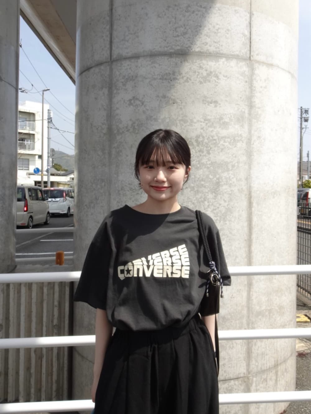 グレー系のTシャツ/カットソー、ブラック系のスラックス、グレー系のショルダーバッグを着用したレディースの春コーディネートの4枚目の写真