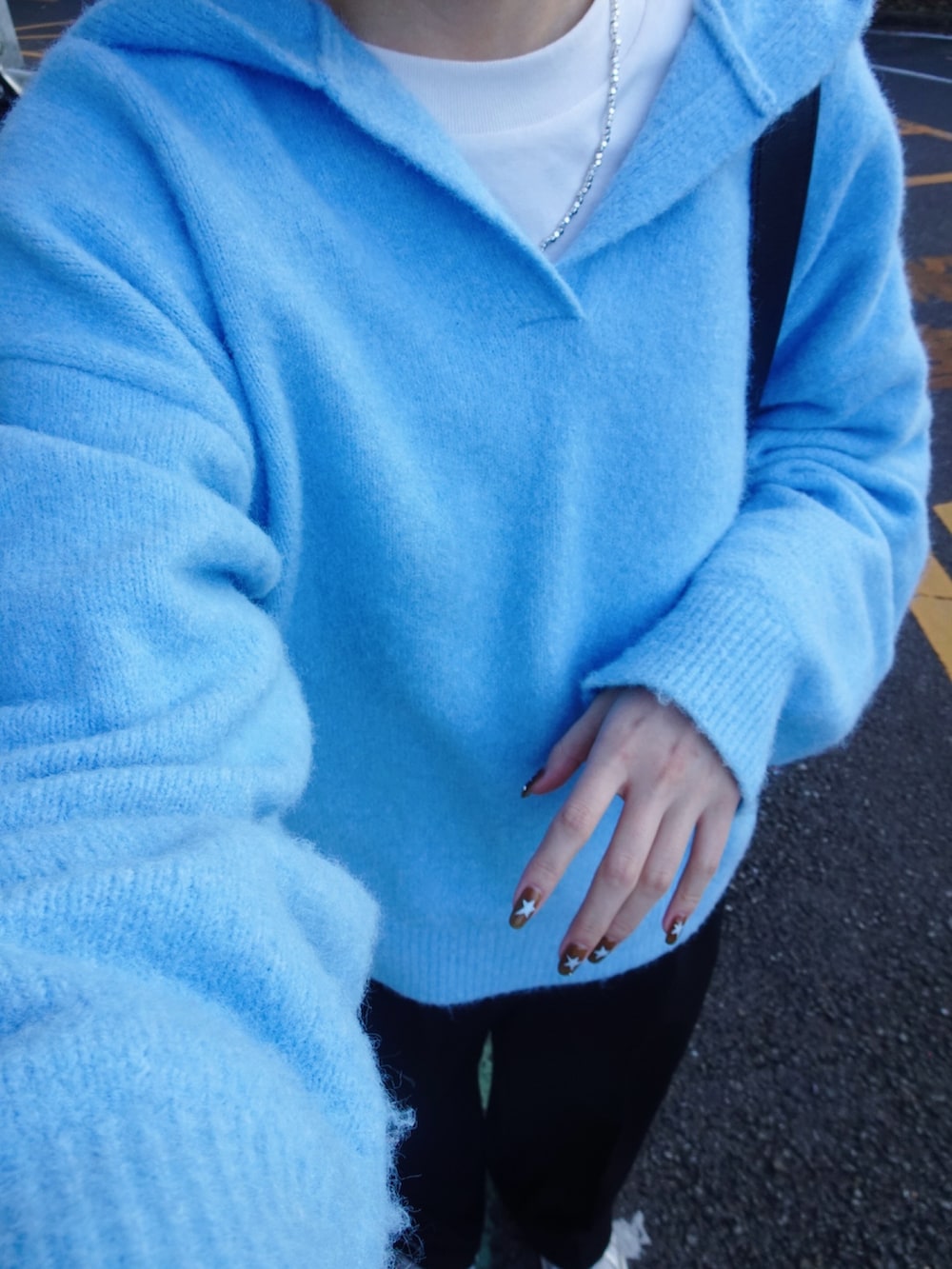 ブラック系のスラックス、ブルー系のニット/セーター、ホワイト系のスニーカーを着用したレディースの冬コーディネートの7枚目の写真