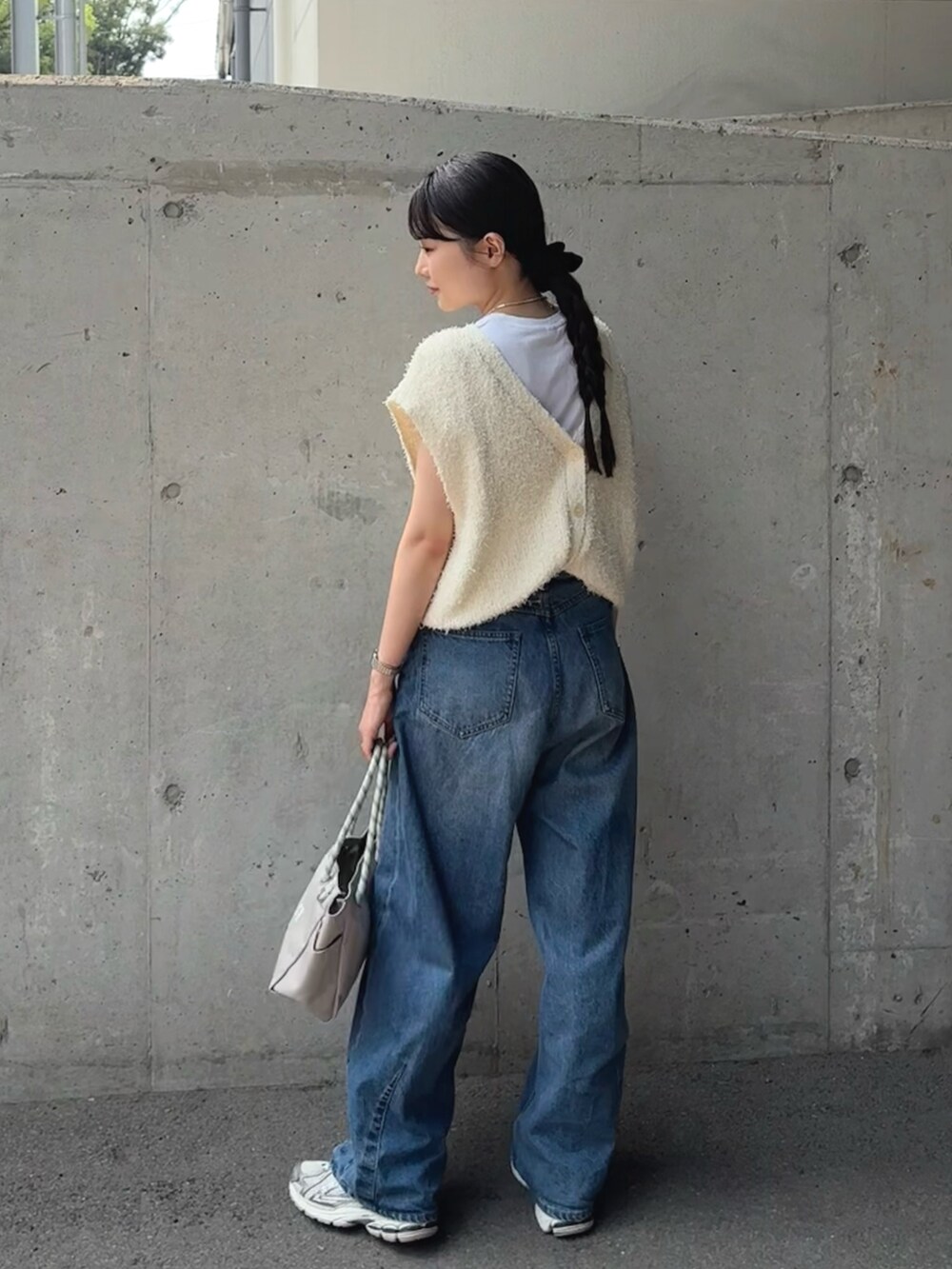 ホワイト系のベスト、ブルー系のデニムパンツ、グレー系のトートバッグを着用したレディースの夏コーディネートの5枚目の写真