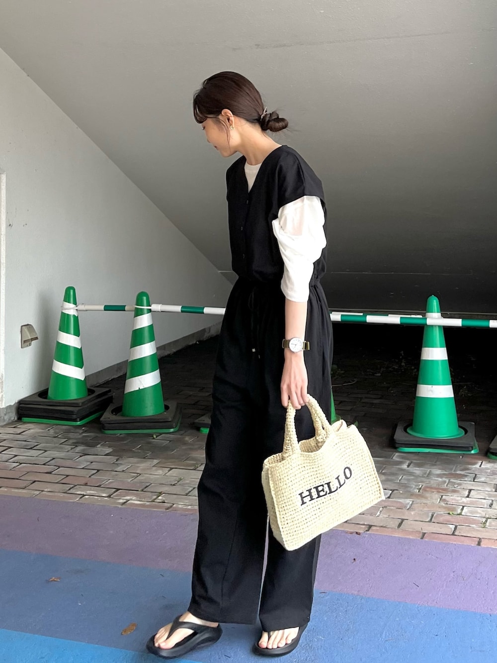 ブラック系のサロペット/オーバーオール、ホワイト系のTシャツ/カットソー、ベージュ系のかごバッグを着用したレディースの春コーディネートの2枚目の写真