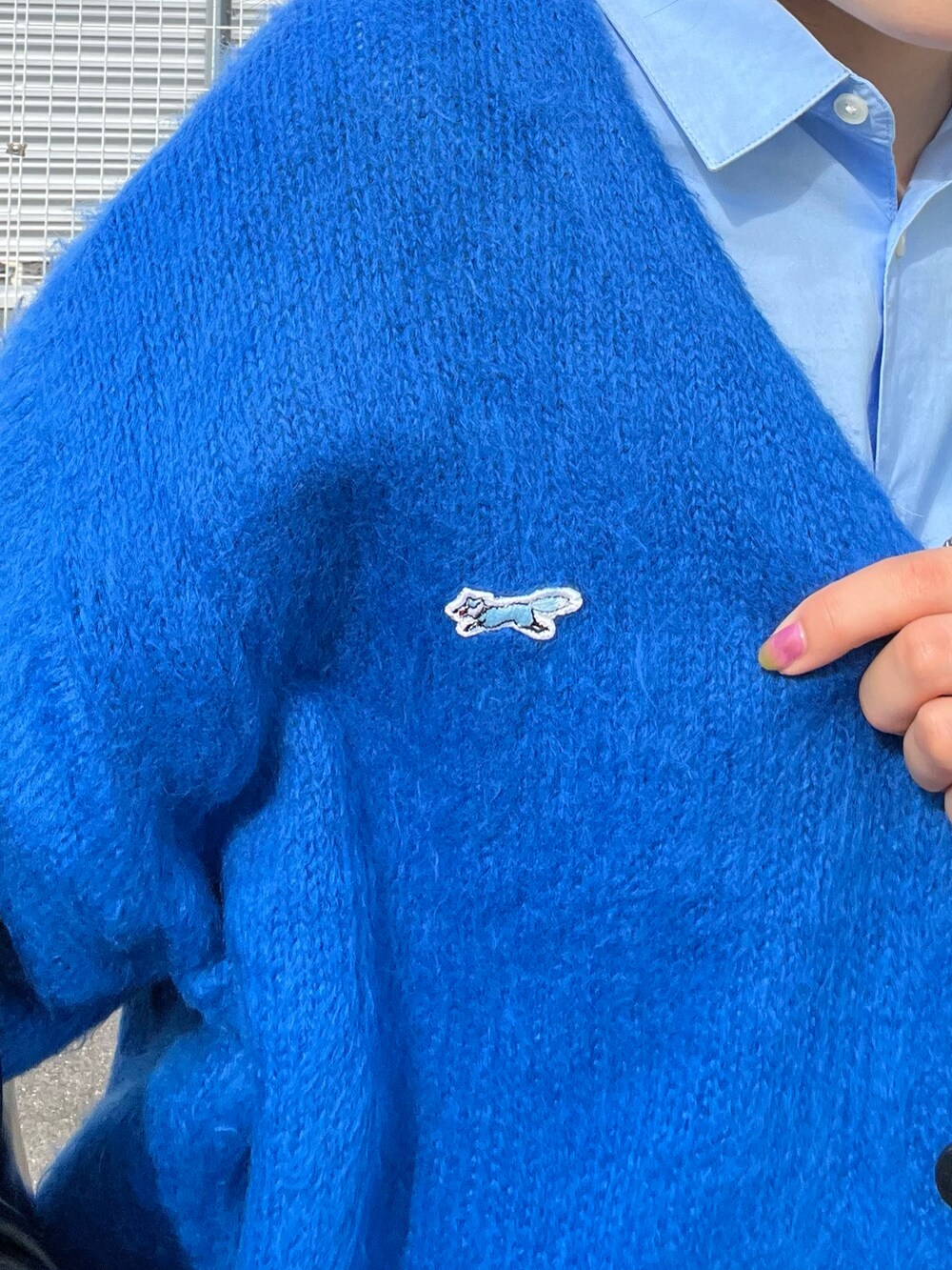 グレー系のスラックス、ブルー系のシャツ/ブラウス、ブラック系のスニーカーを着用したレディースの秋コーディネートの4枚目の写真