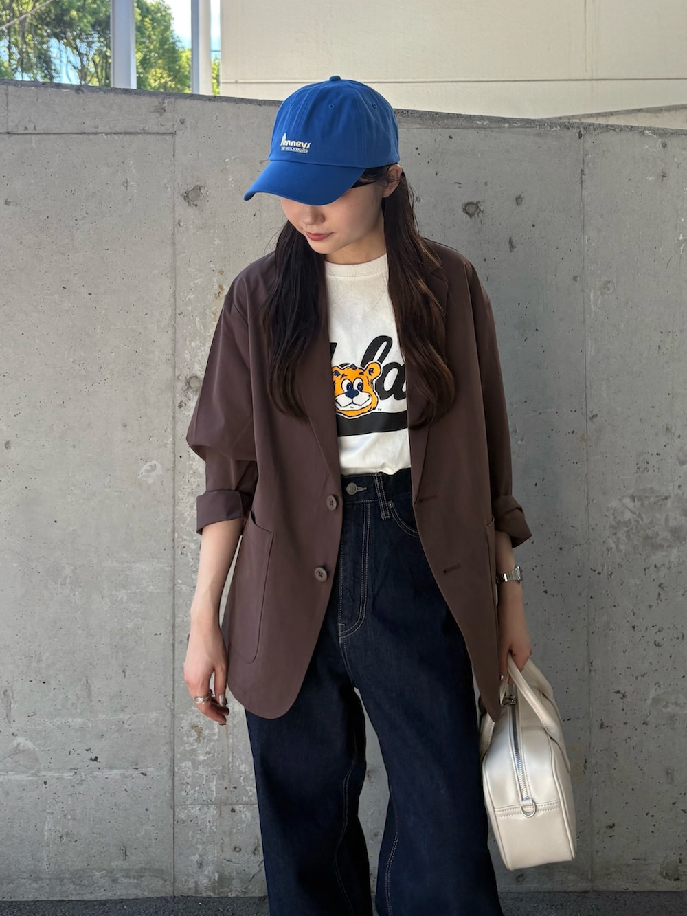 ブラウン系のテーラードジャケット、ホワイト系のTシャツ/カットソー、ホワイト系のショルダーバッグを着用したレディースの秋コーディネートの4枚目の写真