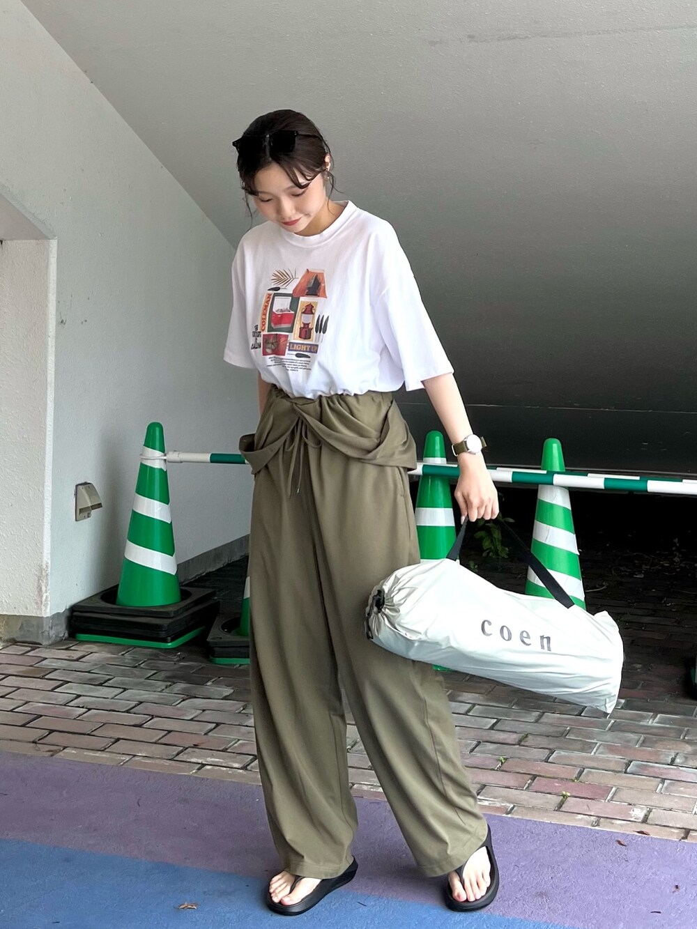 ブラック系のサンダル、グリーン系のサロペット/オーバーオール、その他のTシャツ/カットソーを着用したレディースの春コーディネートの5枚目の写真