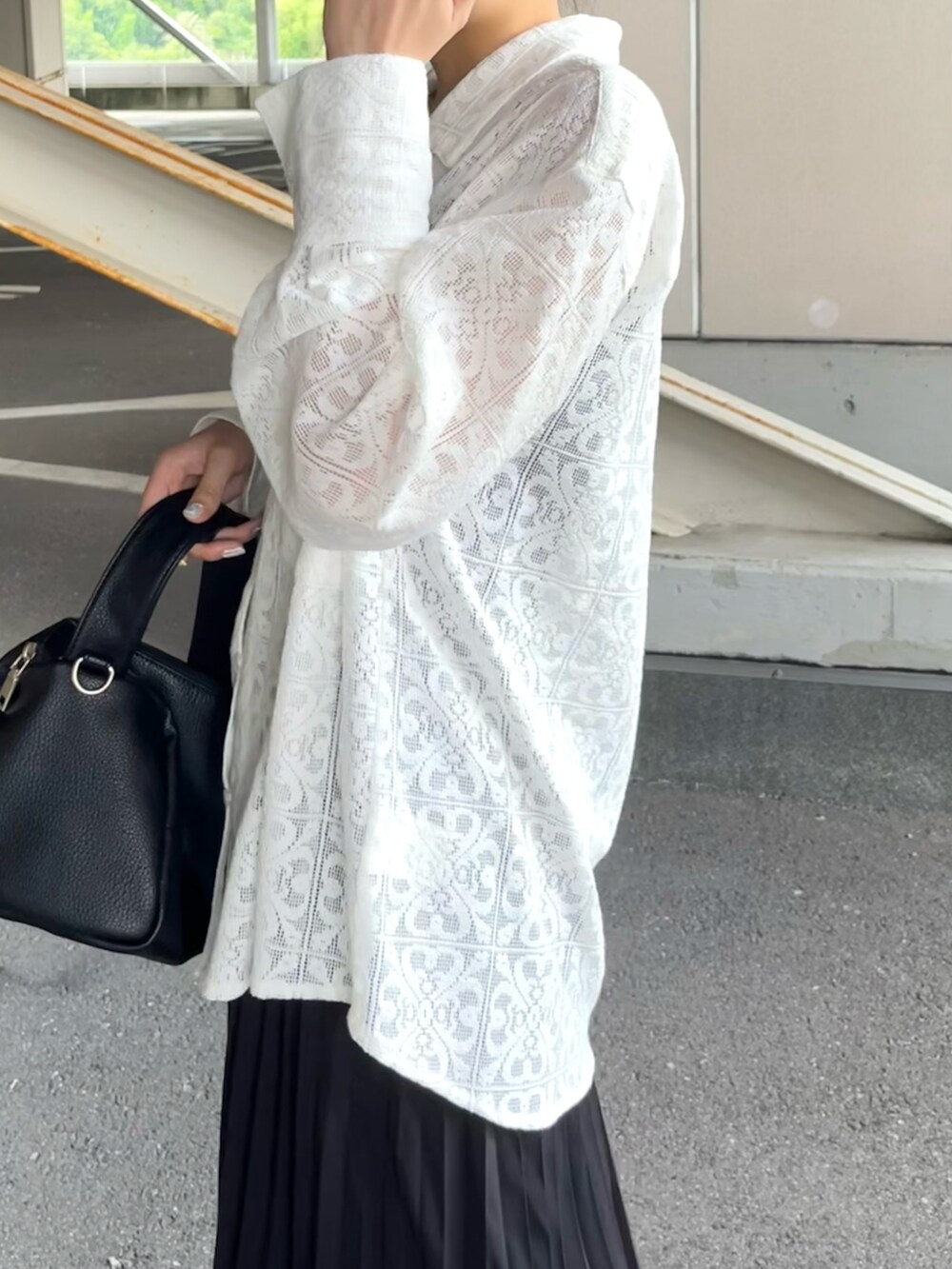 ブラック系のショルダーバッグ、ブラック系のスカート、ホワイト系のシャツ/ブラウスを着用したレディースの夏コーディネートの4枚目の写真