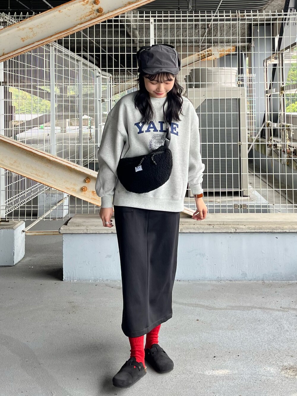 グレー系のスウェット、ブラック系のスカート、ブラック系のサンダルを着用したレディースの冬コーディネートの2枚目の写真