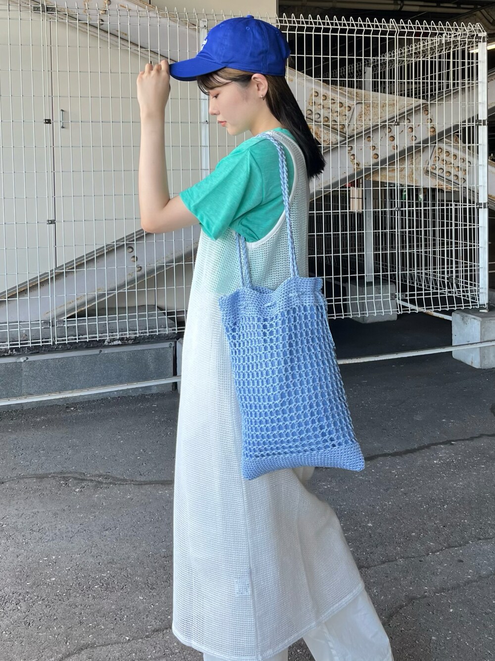 グリーン系のTシャツ/カットソー、ホワイト系のワンピース、ブルー系のトートバッグを着用したレディースの夏コーディネートの2枚目の写真