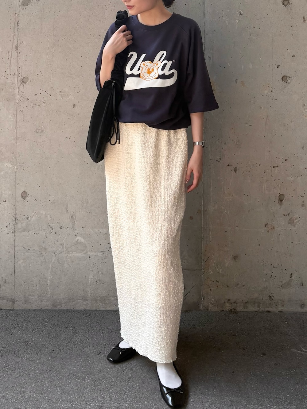 ブルー系のTシャツ/カットソー、ホワイト系のスカート、ブラック系のショルダーバッグを着用したレディースの秋コーディネートの4枚目の写真