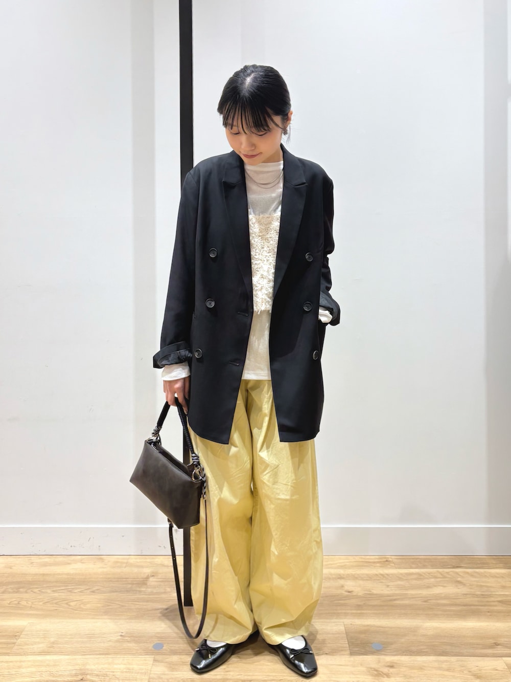 ブラック系のテーラードジャケット、ホワイト系のTシャツ/カットソー、ホワイト系のキャミソールを着用したレディースの春コーディネートの3枚目の写真