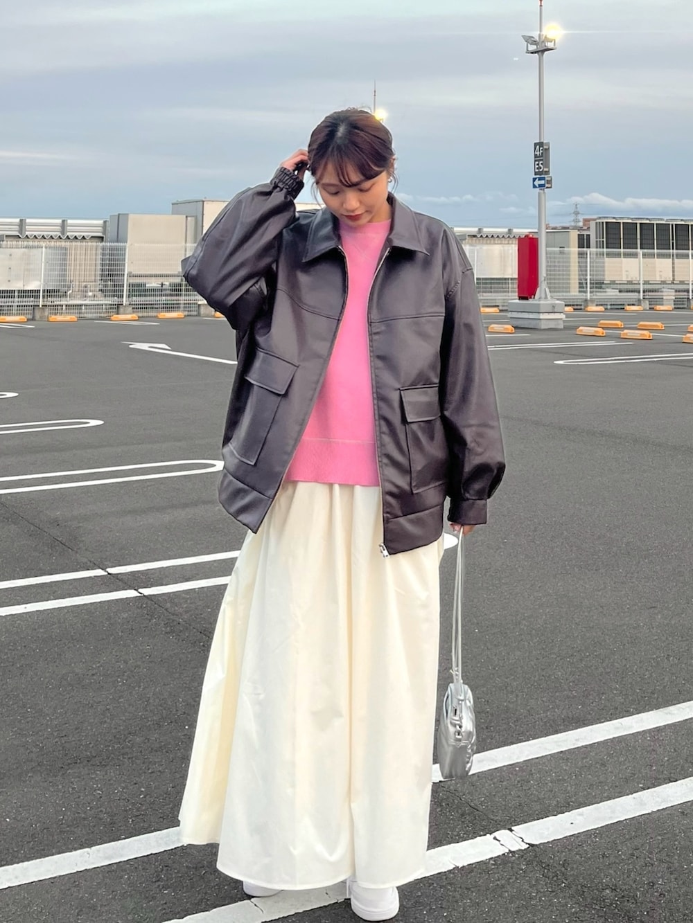 ピンク系のニット/セーター、ブラウン系のブルゾン、ホワイト系のスカートを着用したレディースの冬コーディネートの5枚目の写真