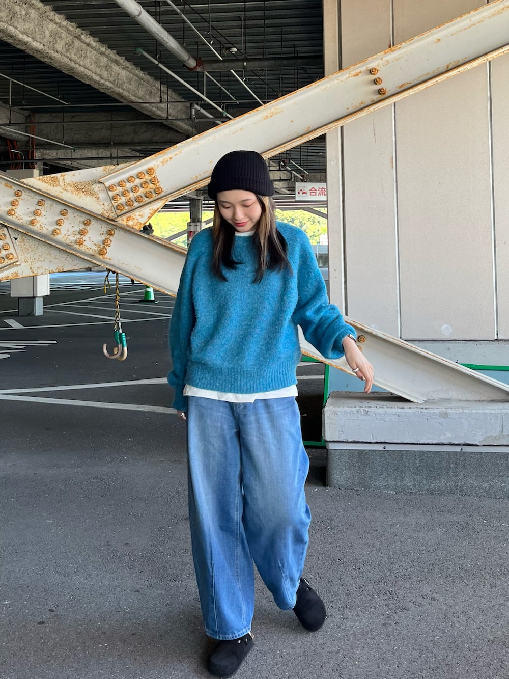 ブルー系のニット/セーター、ホワイト系のTシャツ/カットソー、ブルー系のデニムパンツを着用したレディースの秋コーディネートの2枚目の写真