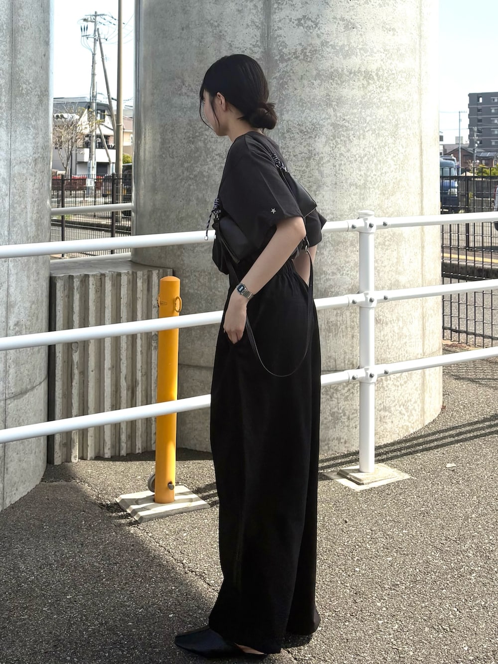 グレー系のTシャツ/カットソー、ブラック系のスラックス、グレー系のショルダーバッグを着用したレディースの春コーディネートの2枚目の写真