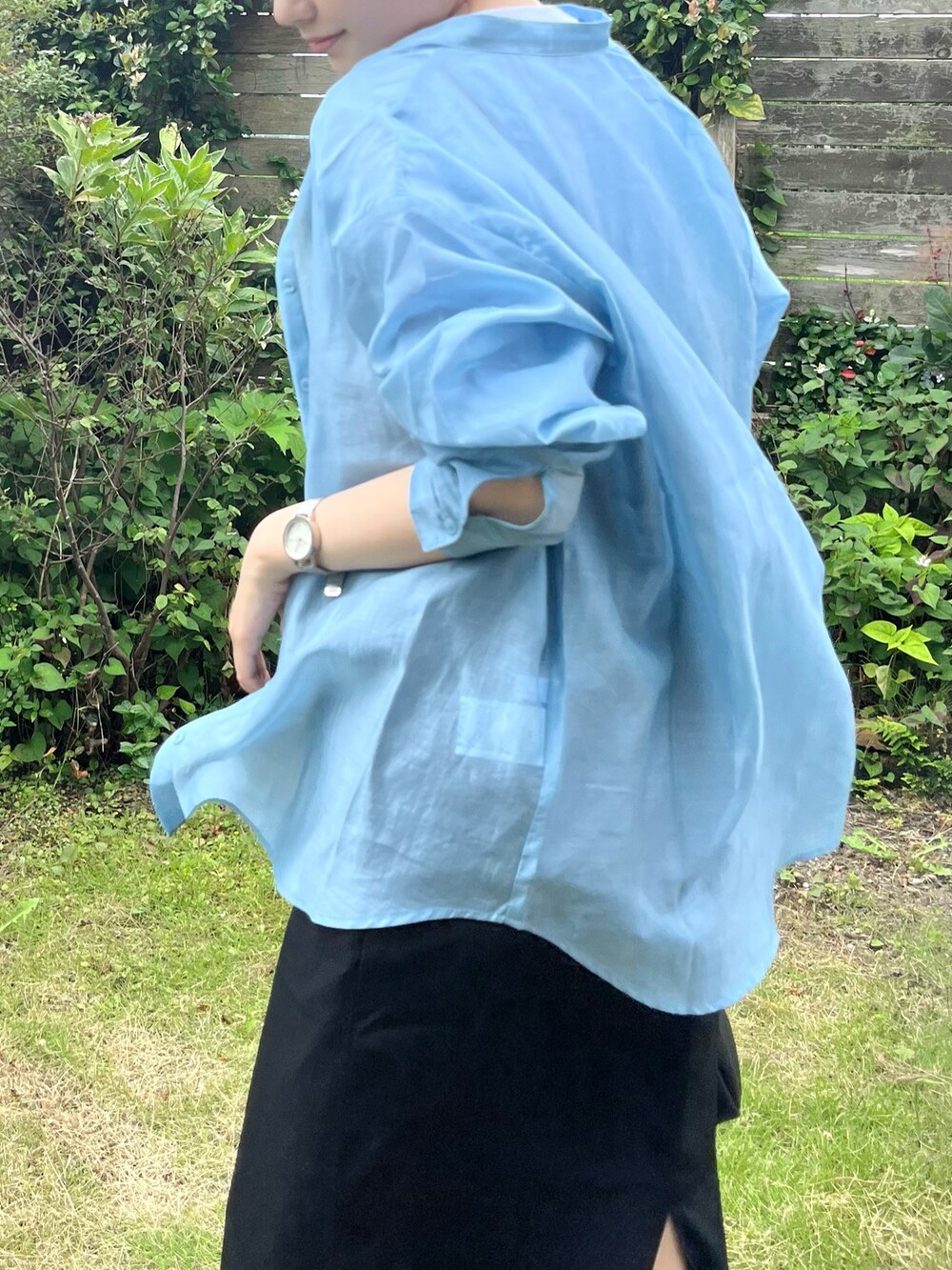 ブラック系のワンピース、ブラック系のショルダーバッグ、ブルー系のシャツ/ブラウスを着用したレディースの夏コーディネートの2枚目の写真