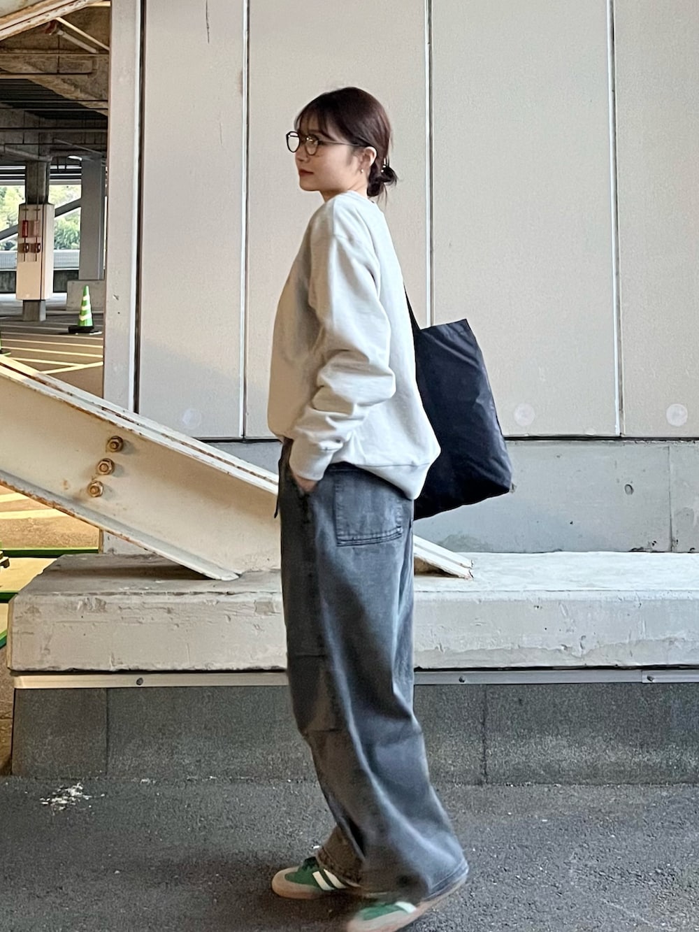 グレー系のデニムパンツ、ブラック系のトートバッグ、グリーン系のスニーカーを着用したレディースの冬コーディネートの2枚目の写真