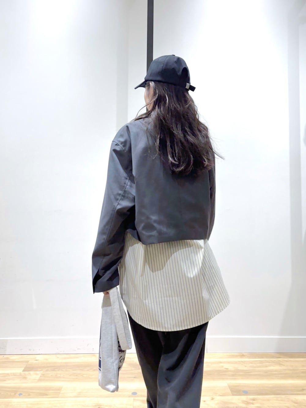 グレー系のテーラードジャケット、ベージュ系のシャツ/ブラウス、グレー系のスラックスを着用したレディースの春コーディネートの2枚目の写真