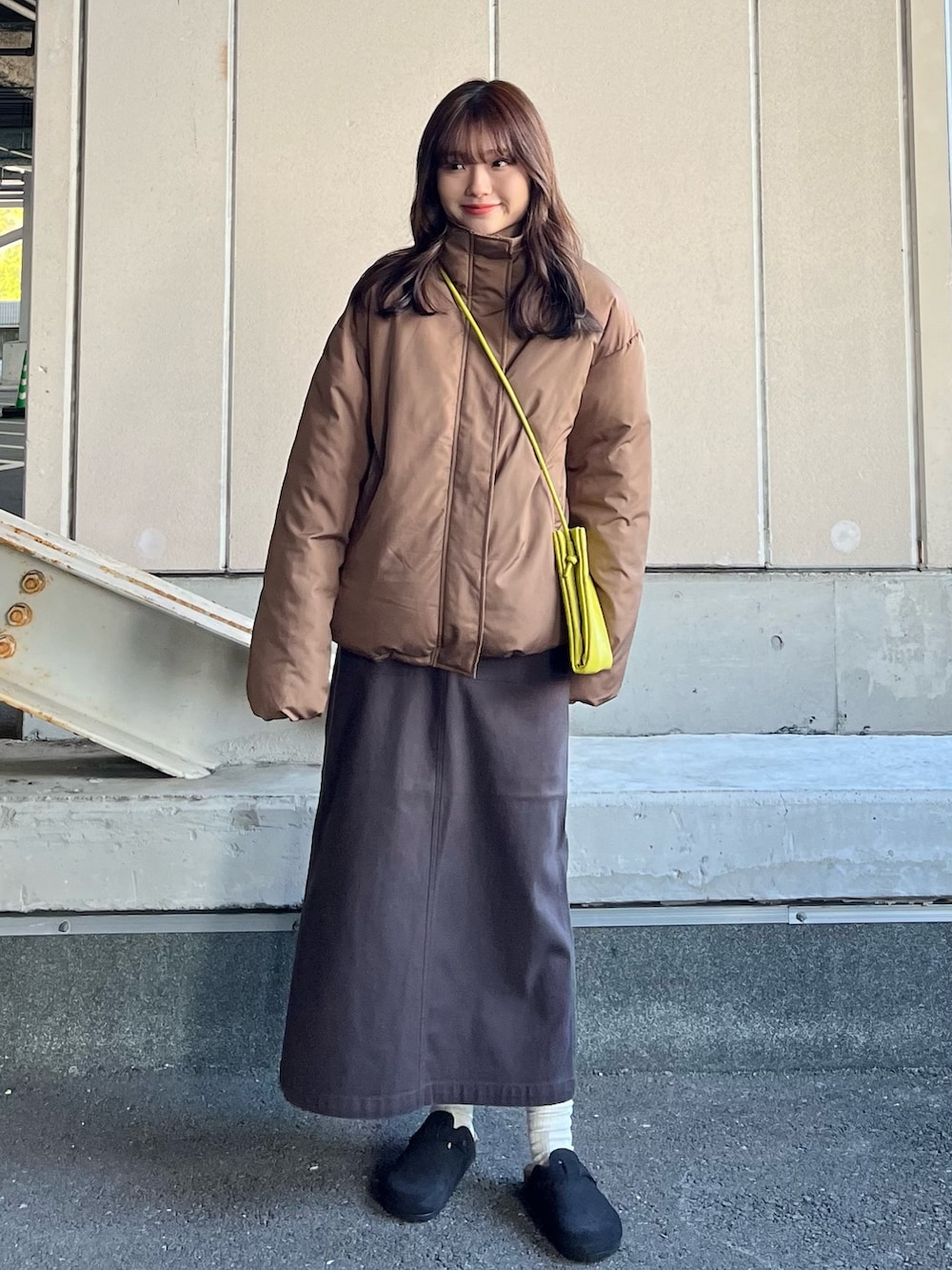 グリーン系のショルダーバッグ、ブルー系のTシャツ/カットソー、ブラウン系のその他アウターを着用したレディースの冬コーディネートの2枚目の写真