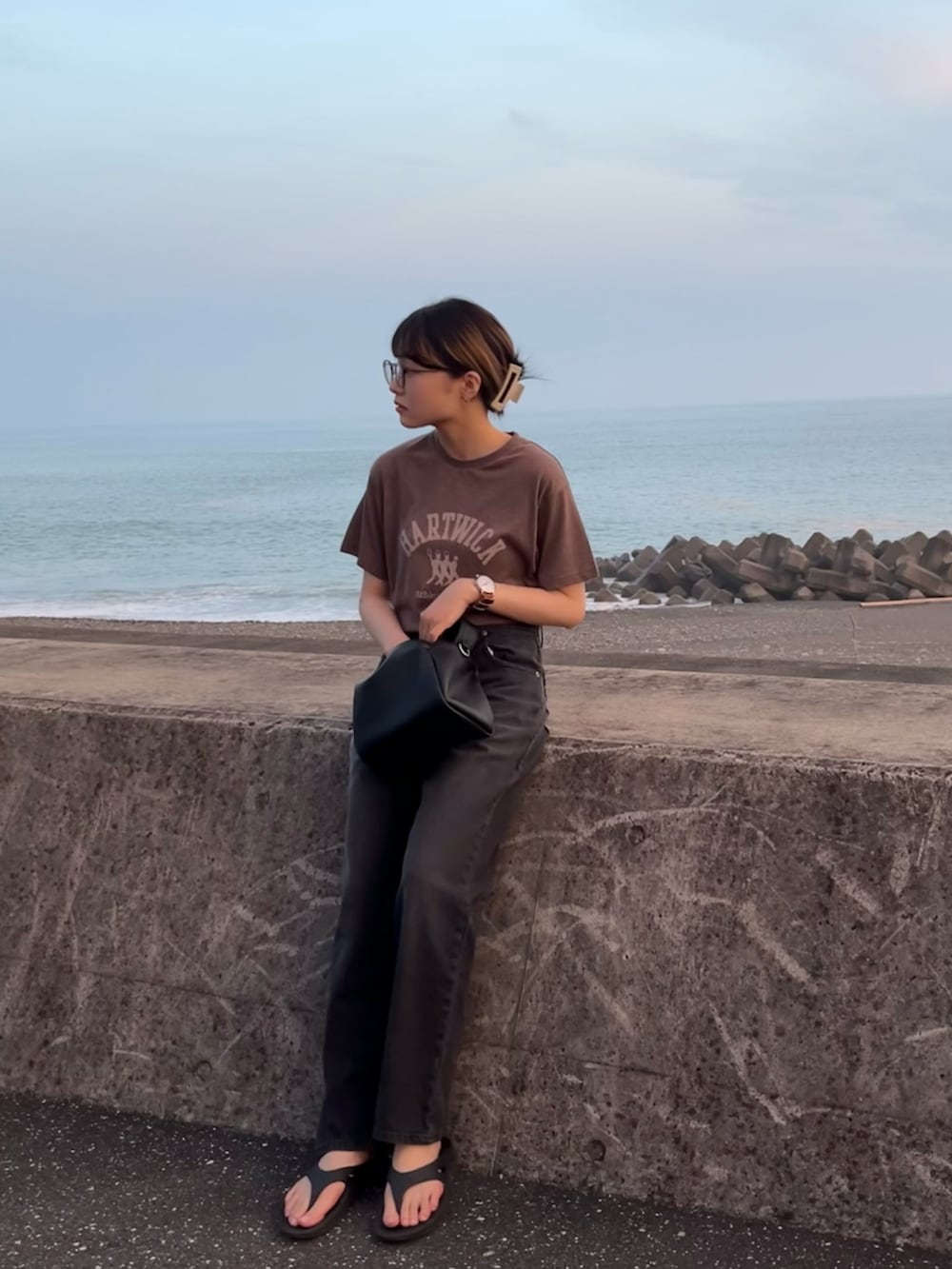 ブラウン系のTシャツ/カットソー、ブラック系のショルダーバッグ、ブラック系のデニムパンツを着用したレディースの夏コーディネートの2枚目の写真